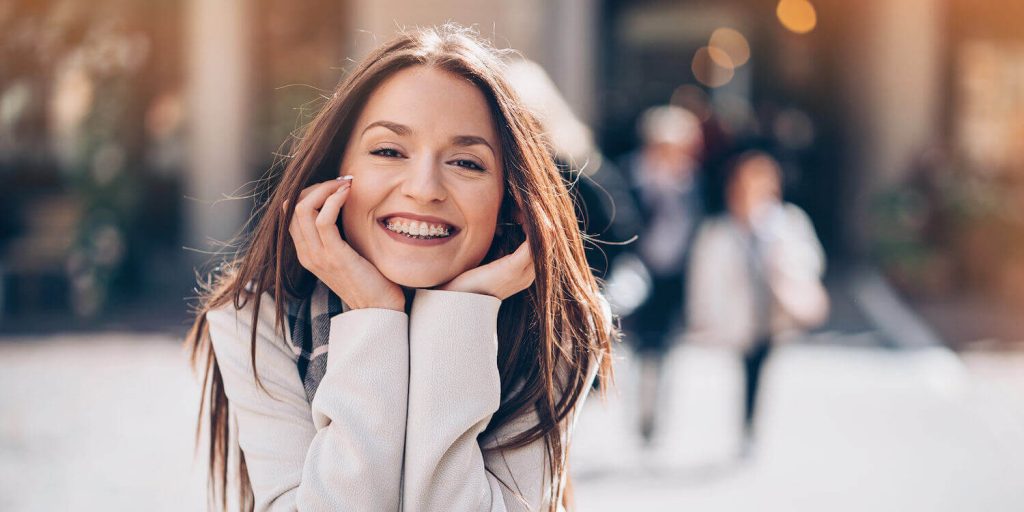 Brunette woman with clear braces smiles happily in Weatherford, TX