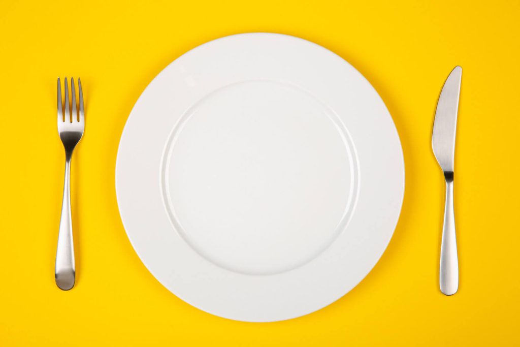 Aerial view of an empty place setting on a yellow background